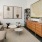 a living room with a grey couch, coffee table, bookcase, and entertainment cabinet