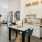 a kitchen with white cabinets, a kitchen island with barstools, and view of dining area