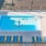 Aerial view of the pool area at our apartments for rent in Stamford, CT, featuring beach chairs, tables, and a tiled pool.